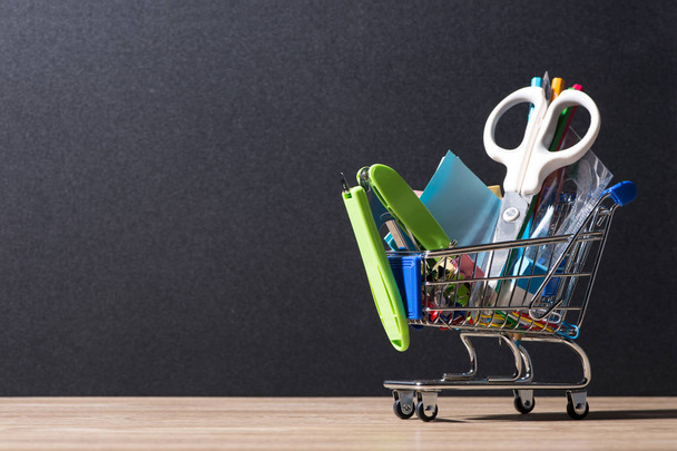 Blackboard and shopping cart with supplies - Фото, зображення