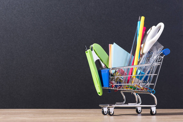 Blackboard and shopping cart with supplies - Φωτογραφία, εικόνα