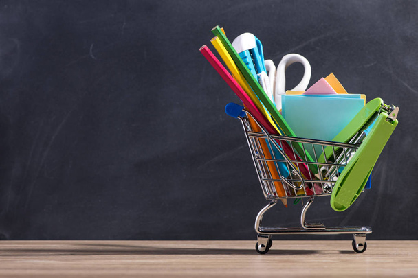 Blackboard and shopping cart with supplies - Photo, Image