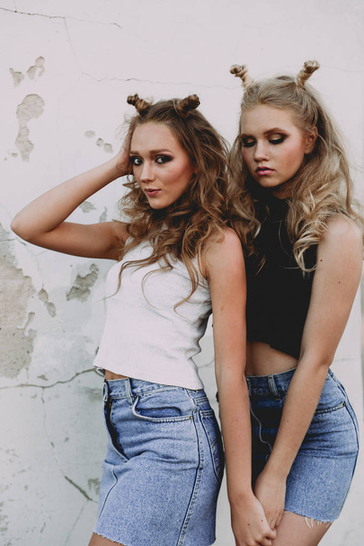 style de vie et concept de personnes : Portrait de mode de deux filles élégantes meilleurs amis portant des jupes en jeans, à l'extérieur sur le toit. Bonne heure d'été pour s'amuser
. - Photo, image
