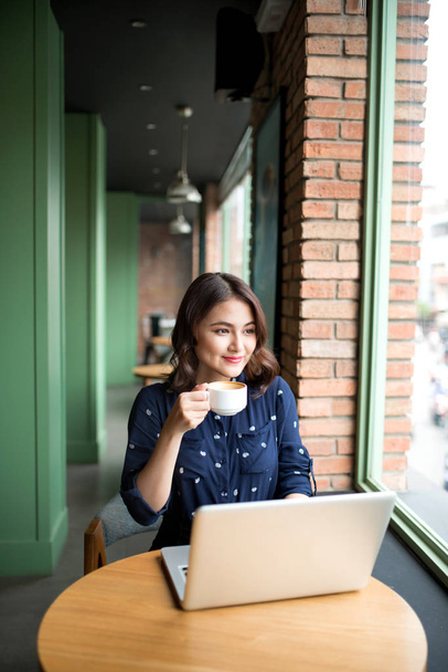 businesswoman sitting in cafe using laptop - 写真・画像
