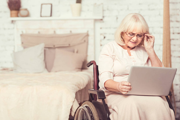 Senior disabled woman using modern device at home - Foto, imagen