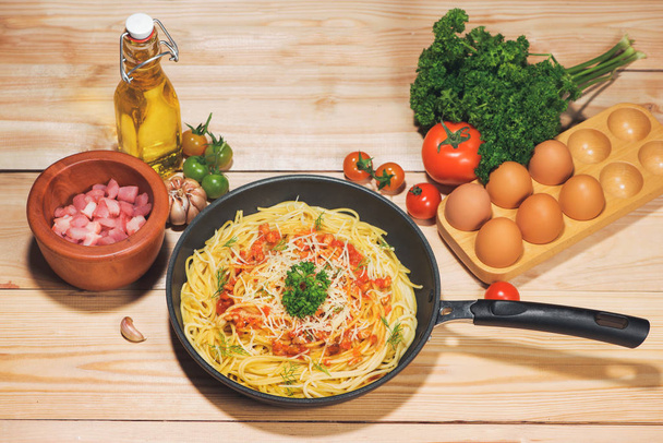Tasty spaghetti with tomato sauce and meat in pan on wooden table - Photo, Image