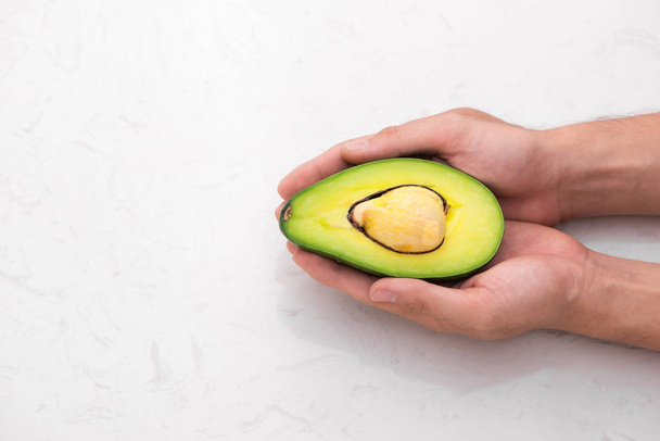 Healthy food concept. Fresh organic avocado on table - Фото, зображення