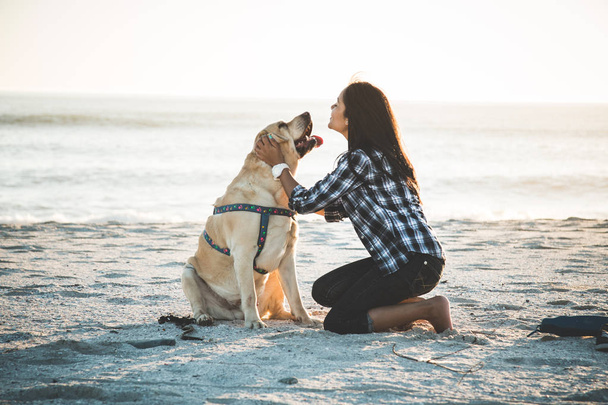 ビーチに犬と遊ぶ少女 - 写真・画像