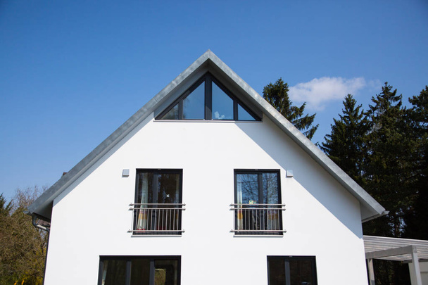  Maison individuelle avec toit en selle, façade blanche
 - Photo, image