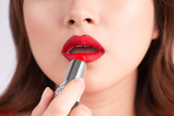 vrouw met behulp van rode lippenstift - Foto, afbeelding