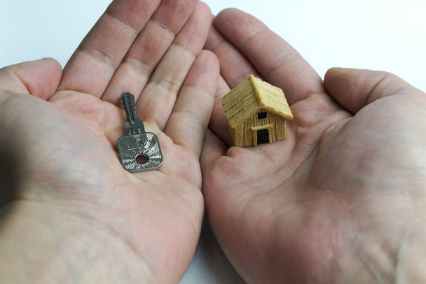 Στο ένα χέρι ένα κλειδί για ένα άλλο σπίτι. - Φωτογραφία, εικόνα