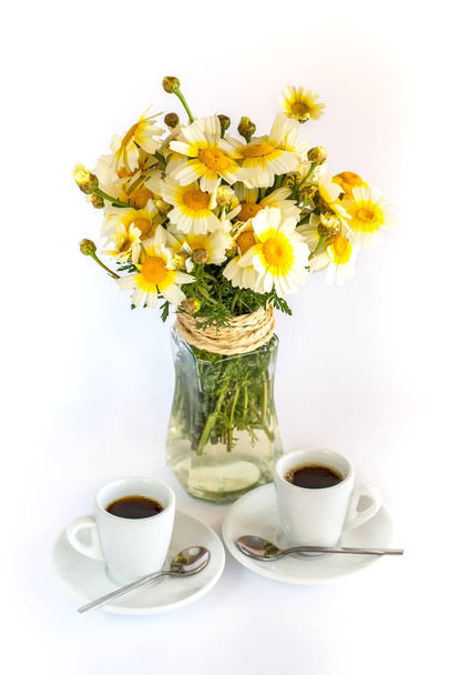 Two cups of coffee and a bouquet of camomiles in the vase - Fotoğraf, Görsel