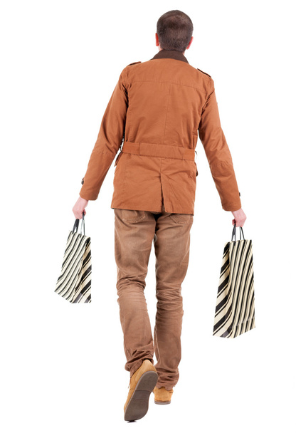 Back view of going handsome man with shopping bags. - Foto, Imagen