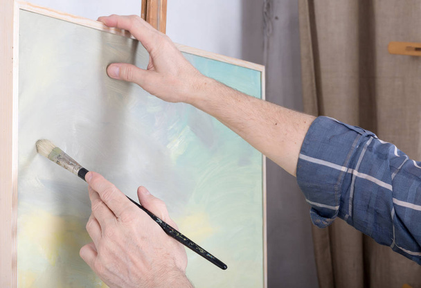 An artist painting in studio - Фото, зображення