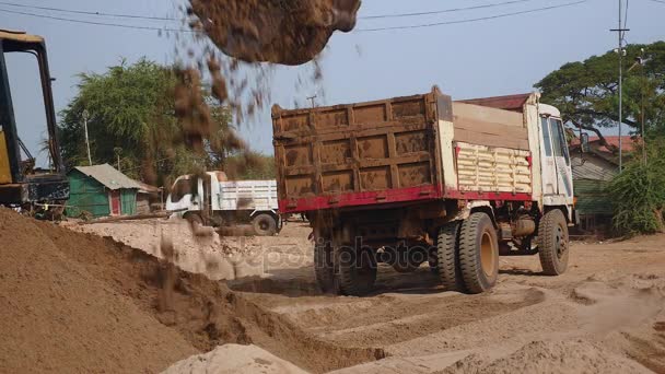 Екскаватор завантажує пісок у вантажівку
 - Кадри, відео