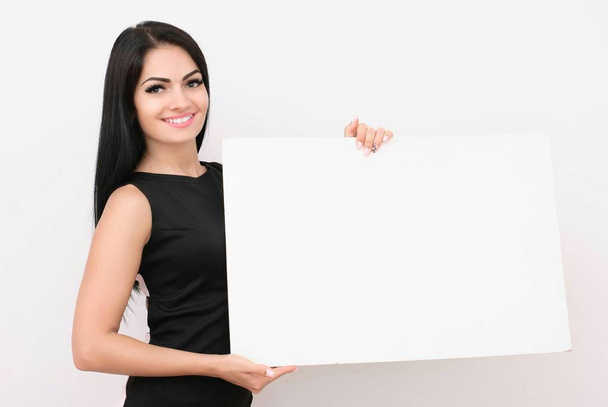 Portrait of smiling business woman with blank white sign board. Isolated studio portrait. - Zdjęcie, obraz