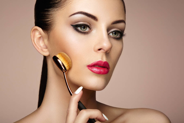 Makeup artist applies skintone with brush - Photo, Image