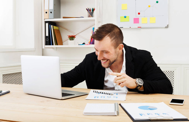 Sonriente empresario exitoso con el ordenador portátil
 - Foto, imagen