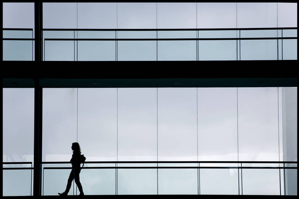 Vista de la silueta de la joven empresaria en un moderno edificio de oficinas interior
 - Foto, Imagen
