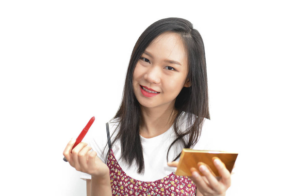 Azjatyckie kobiety stosujące czerwona szminka ołówkiem kosmetycznych na li - Zdjęcie, obraz