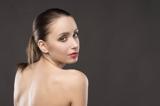 the beautiful girl naked shoulders portrait on a gray background - Foto, immagini