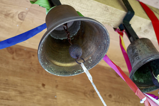 Vieilles cloches d'église en laiton dans une tour attachée avec des rubans colorés
 - Photo, image