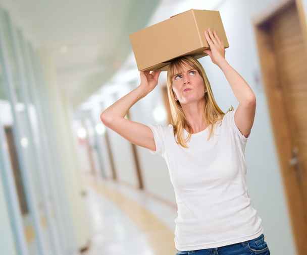 mulher segurando uma caixa na cabeça
 - Foto, Imagem