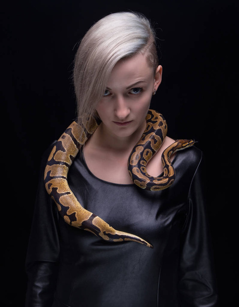 Woman in leather dress and royal python - Foto, Imagen