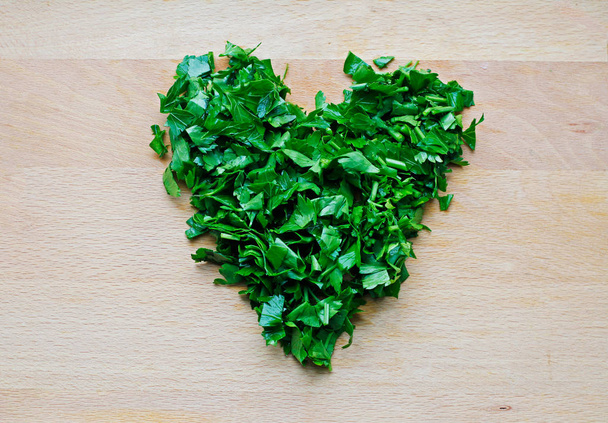 Heart shape of green parsley on wooden background - Фото, изображение