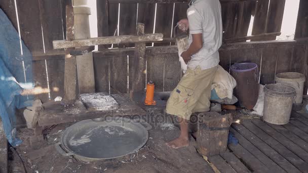 homme utilisant machine de pressage pour couper la pâte de riz en bandes
  - Séquence, vidéo