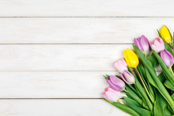 Bunch of colored tulips on a white wooden background - Fotoğraf, Görsel