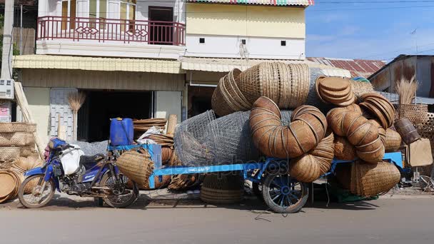 Moottoripyörän perävaunu, joka on lastattu bambu-tuotteilla käsityöliikkeen edessä
 - Materiaali, video
