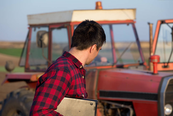 Farmer with laptop and tractor - 写真・画像