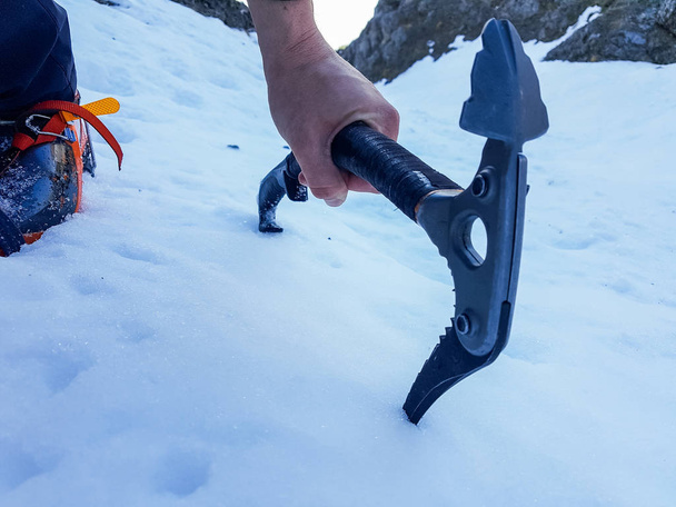 Closeup of ice axe on steep slope. - Photo, Image