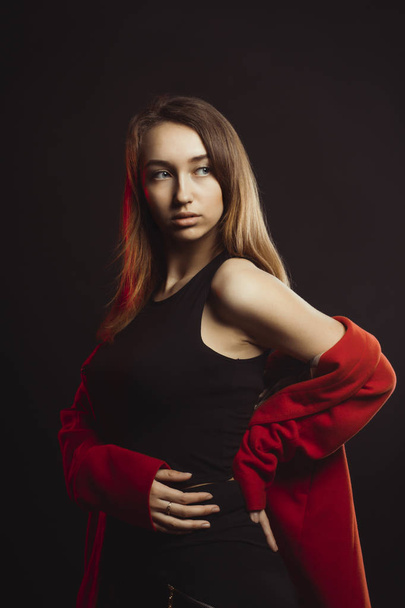 Модна молода жінка в червоному пальто в студії
 - Фото, зображення