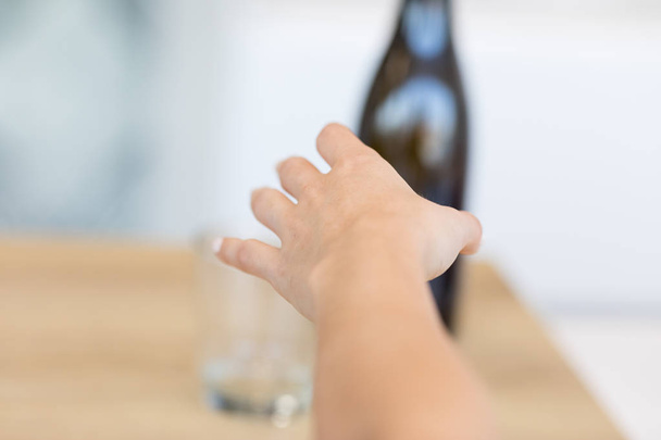 Vrouwelijke hand die reikt na fles - Foto, afbeelding