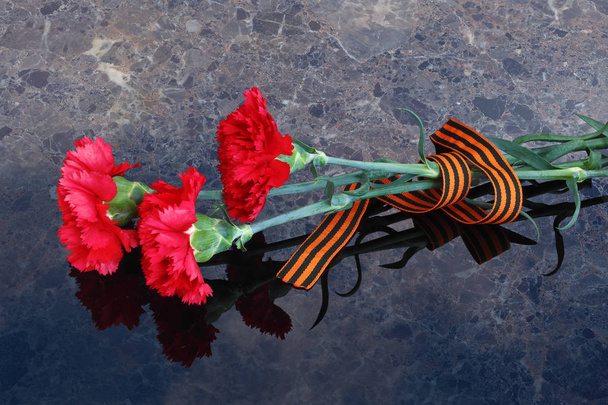 claveles rojos con cinta de San Jorge
 - Foto, imagen