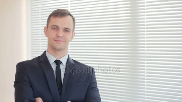 Young businesswoman standing in office on background of curtains looking at camera and smiling - Materiał filmowy, wideo