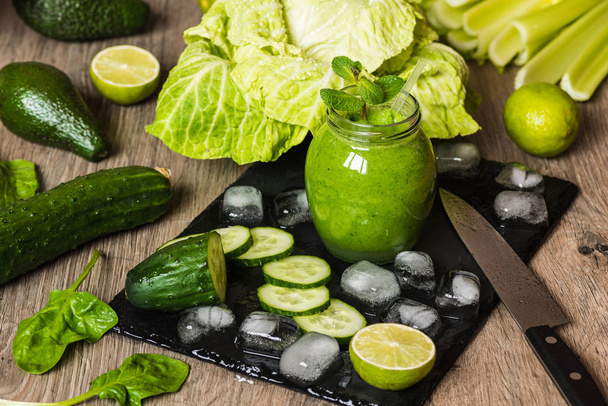 デトックス ダイエット。木製の背景に別の野菜で緑のスムージー - 写真・画像