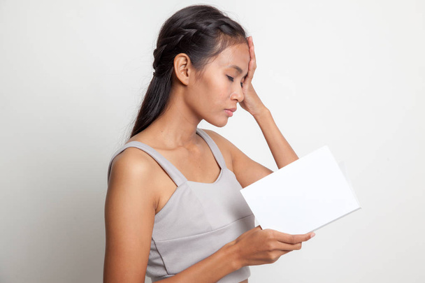 Young Asian woman got headache read a book. - Фото, изображение