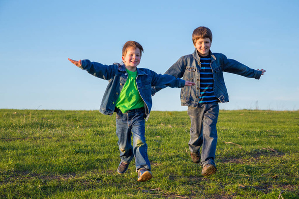 Two brothers running together on meadow - Fotografie, Obrázek
