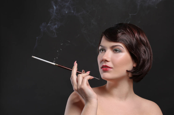 woman smoking with cigarette holder - Photo, image
