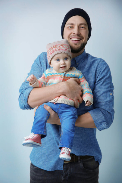 Father posing with cute baby daughter on light background - Photo, Image