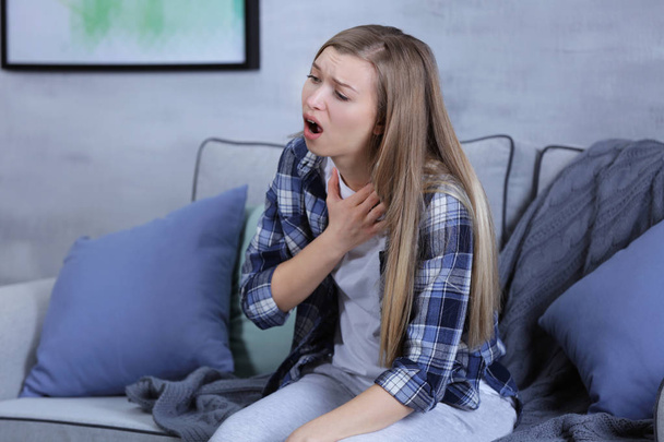 Sick young woman coughing at home - 写真・画像