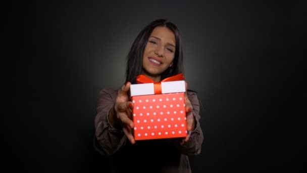 Onnellinen kaunis nainen tilalla ja osoittaa syntymäpäivä lahja laatikko läsnä
 - Materiaali, video