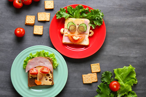 Plates with tasty sandwiches on grey background - Фото, изображение