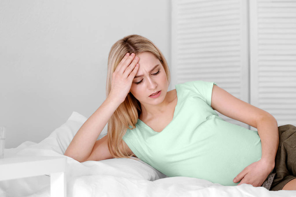 Young pregnant woman suffering from headache at home - Valokuva, kuva