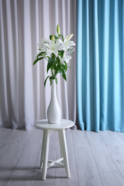 Beautiful white lilies in vase on stool - Fotoğraf, Görsel