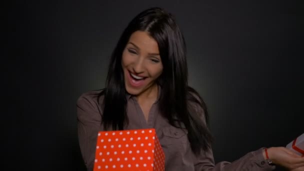 Beautiful young woman getting excited while she opens her gift box - Felvétel, videó