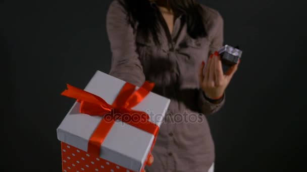 Close up with woman hands holding a big and small gift boxes and showing them as alternative - Video, Çekim