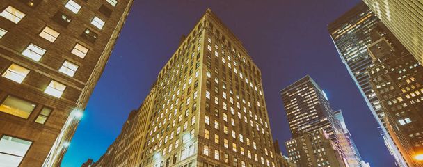 Vista nocturna de edificios de Nueva York desde el nivel de la calle
 - Foto, Imagen