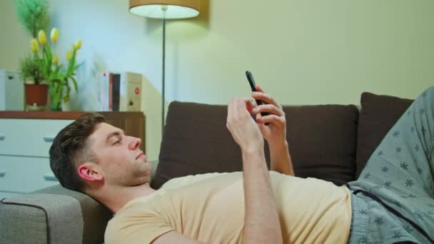 Hombre acostado en el sofá y el uso de teléfono móvil
 - Imágenes, Vídeo