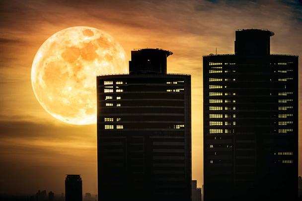 Silhouettes of two skyscrapers different  construction with background of super moon - Photo, Image